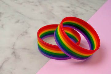 rainbow bracelets on a shiny pink and marble background. the celebration of Valentine's Day. The view from the top. The concept of the festival LGBT