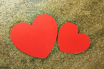 Red hearts on a golden glitter background.