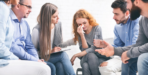 Depressed crying woman receiving empathy from Support Group members