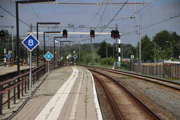 Red signs above railroad tracks heading to Rotterdam at Gouda Railway Station