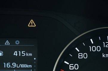 Exclamation mark indicator on car dashboard. Close-up. malfunction warning.