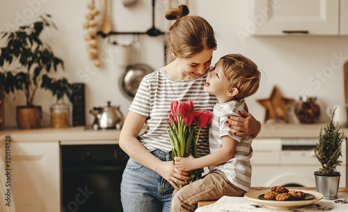 happy mother's day! child son gives flowers for  mother on holiday