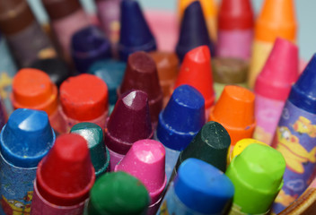 colored wax pencils in a glass on a blue background