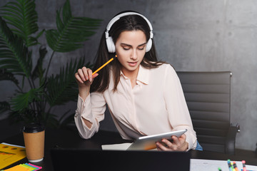 Front view. Girl sits in cafe at table in front of open laptop computer. Woman works on computer, checks email. Freelancer works remotely. Online education for adult.