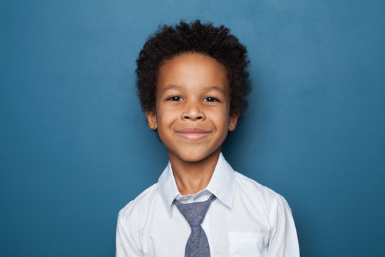 Portrait of black kid boy pupil on blue background. Happy child student school boy