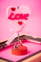 Miniature couple against pink background