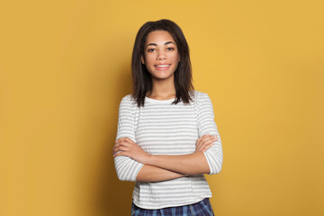 African American woman with crossed arms on yellow background