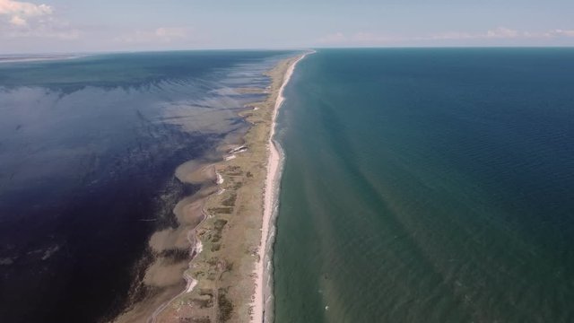 Aerial shot of a boundless limestone sandspit on the Black Sea in summer. 