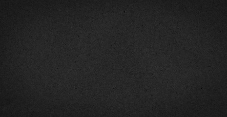 Texture of black gift rough paper with fibers. Dark background for design, template, greeting card, website backdrop.