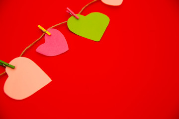 Hearts cut out of paper on a clothespin, Happy valentines day. red color Background