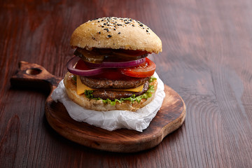 Appetizing burger on the board on a dark wooden table
