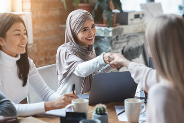 Two girls business colleagues shaking hands in office