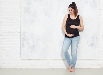 Happy pregnant woman in jeans