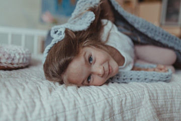 Girl reading a book on a sofa in a cozy room