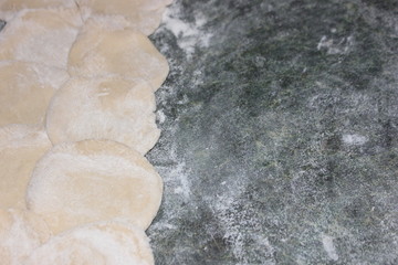 Dumplings for dumplings on a green table. Top view of the dough for ravioli and ravioli. Billets for ravioli broken