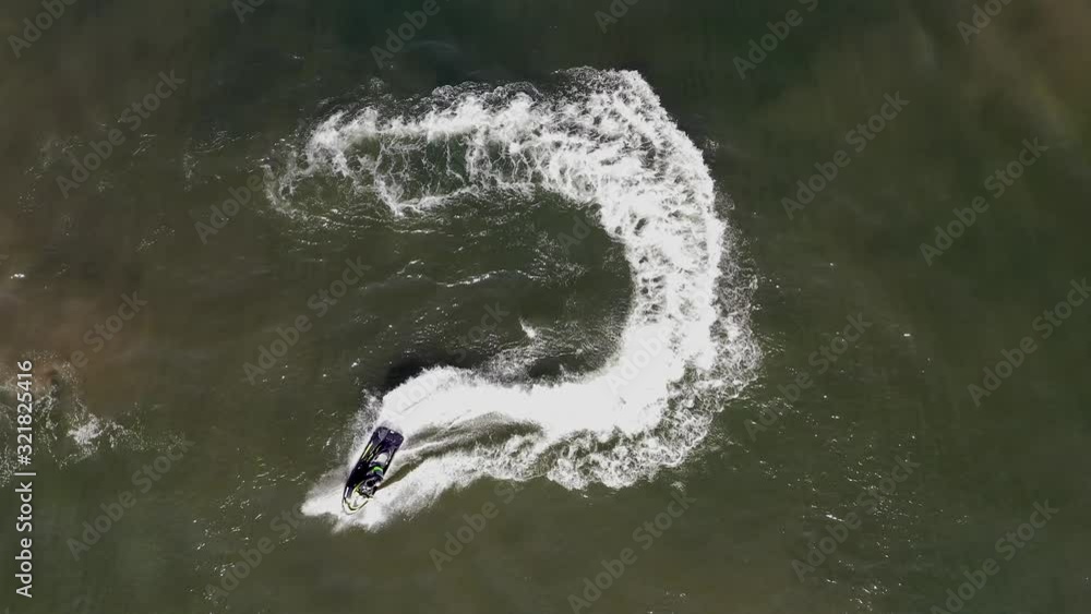 Wall mural jetski roaring across the open waters of the mediterranean sea, aerial footage.