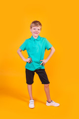 Fototapeta na wymiar Full length portrait of cute little boy in stylish clothes looking at camera and smiling