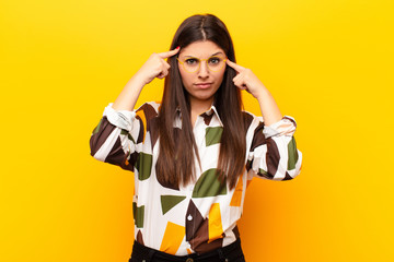 young pretty woman with a serious and concentrated look, brainstorming and thinking about a...
