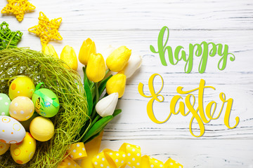 Happy Easter. Congratulatory easter background. Easter eggs and flowers. Selective focus. Top view.