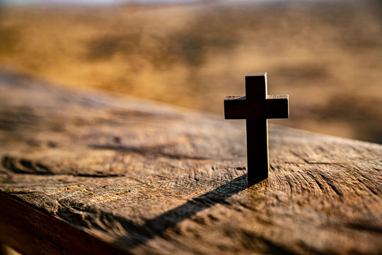 Wooden cross under an old wooden bench