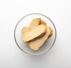 Sliced tempeh appetizer in glass bowl on white background