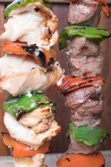 Meat skewer with red and green peppers hung vertically
