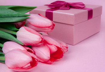 Gift with flowers tulips on a pink background for Valentine's Day, for Mother's Day