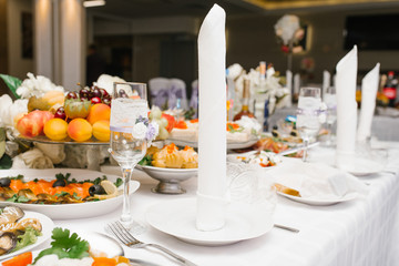 Serving a festive wedding Banquet table. A white napkin is on the plate