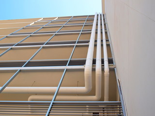 Fototapeta premium Ventilation duct beside the building To extract fumes or other substances On the background of buildings and blue skies With copy space