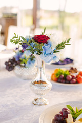 Beautiful silver vase with a bouquet of flowers in the decor of the wedding table and wedding, birthday, home