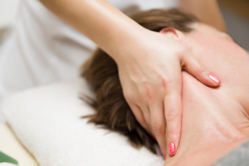 Woman getting a stress relieving pressure point massage on her neck by a health therapist
