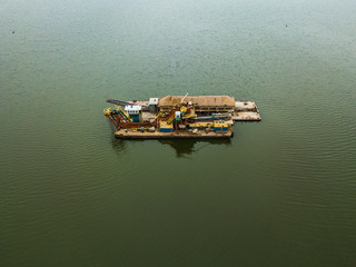 Sand mining machine in the middle of the lake