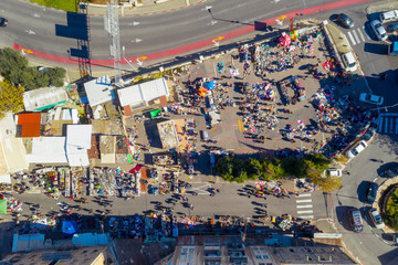 Flea Market in an Old city street with People and Colourful goods on display, Top down aerial view.