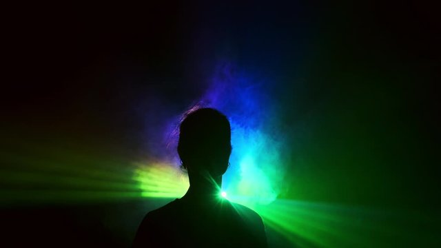 Image Of Young Girl On Light Background Of Different Colors Moving In The Dark. Smoke Fills The Triangle With The Girl's Head. Projector.