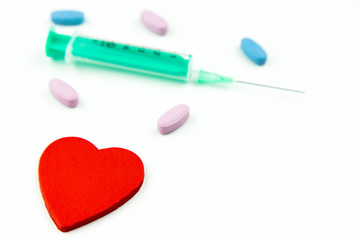 Strzykawka serce oraz tabletki na białym tle
