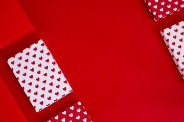 Valentine day composition, flat lay top view. White and red gift boxes with white and red heart on red background. Photo template, background, copy space. View from above