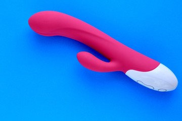Sex toy for adult, design pink dildo vibrator isolated on blue background. Concept of sex,...