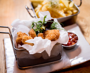 Fried chicken nuggets with french fries and tomato sauce. Restaurant.