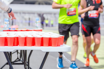 Russia, Samara, June 2019: volunteers give out glasses of water to athletes running a marathon...