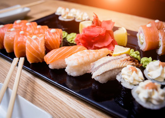Sushi set. Rolls with salmon, eel and red caviar on a wooden plate. Restaurant.