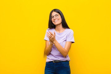 young pretty latin woman feeling happy and successful, smiling and clapping hands, saying...