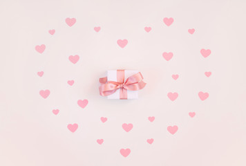 Valentines day composition. Greeting card with hearts and a gift on a pink background. Valentines day concept.