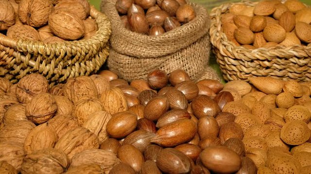 Nuts Mix. Walnuts, Almonds, pili, pecan, peanuts, Hazelnuts are on the Green wooden Surface. Nuts Detail. Nuts Closeup. Food Closeup