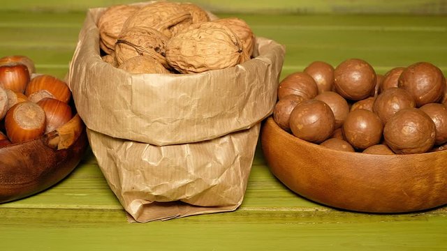 Nuts Mix. Walnuts, Almonds, pili, pecan, peanuts, Hazelnuts are on the Green wooden Surface. Nuts Detail. Nuts Closeup. Food Closeup