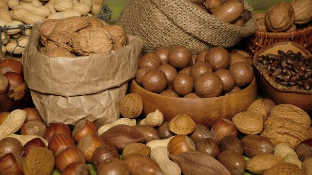 Nuts Mix. Walnuts, Almonds, pili, pecan, peanuts, Hazelnuts are on the Green wooden Surface. Nuts Detail. Nuts Closeup. Food Closeup