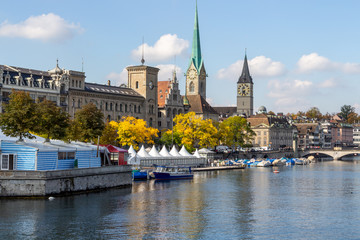 Waterfront of Limmat river in Zurich, Switzerland with ships, churchs and other buildings