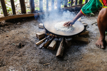 Preparation of manioc flour and Choucaturo caterpillar skewer / Preparation of cassava flour and choucaturo caterpillar skewer on a campfire in the Amazon rainforest, Ecuador.