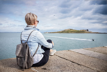 Fototapeta premium Female tourist looking over the island Eye of Ireland