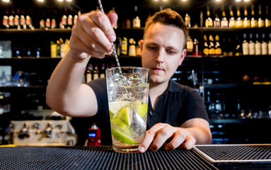 Bartender is making cocktail at bar counter. Fresh cocktails. Barman at work. 