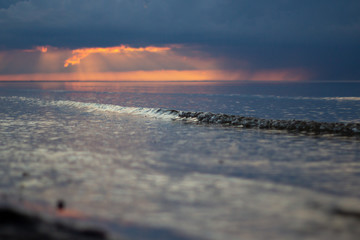 Sea ocean landscape at sunset with volumetric light (god rays) Baltic shore coast at dusk